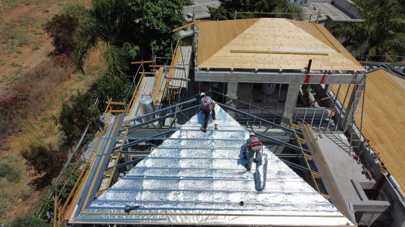 מתקינים פורשים שכבת בידוד פולינום אולטרה על גג מבנה בבנייה במושב אורות