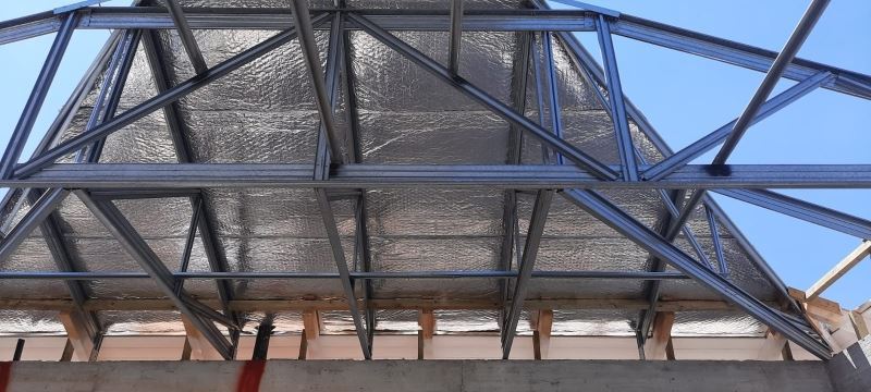 לחיצה להגדלת תמונה שכבת בידוד פולינום אולטרה מותקנת מתחת לקונסטרוקציית פלדה בגג מבנה חדש במושב אורות