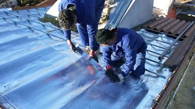 שני מתקינים מניחים ומיישרים שכבת בידוד רפלקטיבית על גג מבנה מסוג Senen במהלך עבודת ההתקנה