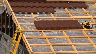 גג מבנה שעליו פרוסה שכבת בידוד רפלקטיבית ומעליה רשת קורות עץ