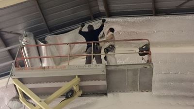 התקנת בידוד רפלקטיבי על מבנה תקרת פנים במחסן Alcamen