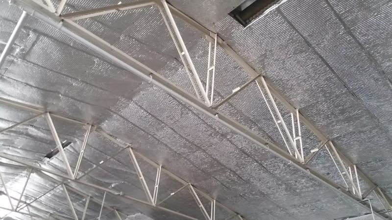 תקרת פנים רחבה המכוסה ביריעות בידוד רפלקטיביות מעל קונסטרוקציית מתכת