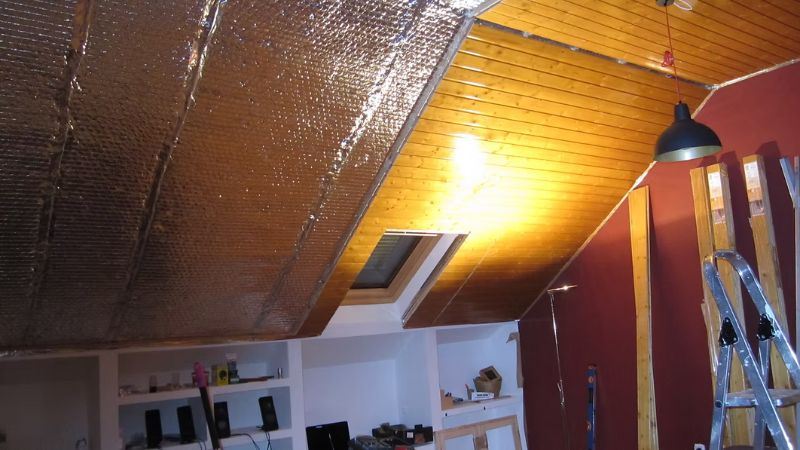 לחיצה להגדלת תמונה חלל עליית גג עם שילוב של חיפוי עץ ויריעות בידוד רפלקטיביות סביב חלון סקיילייט ותאורה תלויה